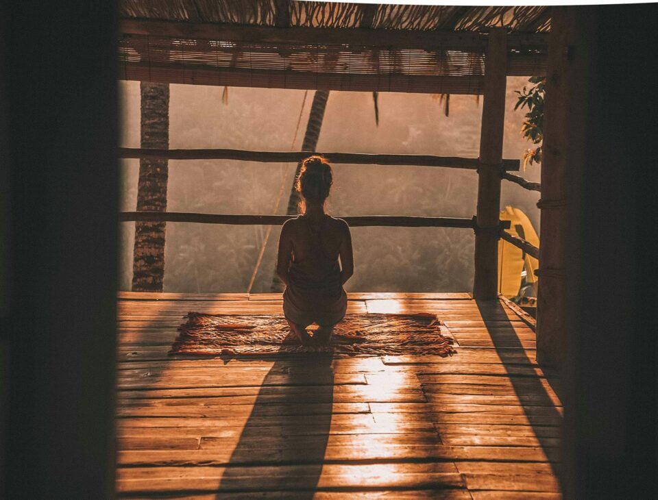 Femme en posture de yoga au lever du soleil face aux rizières de Bali — bien-être Bali