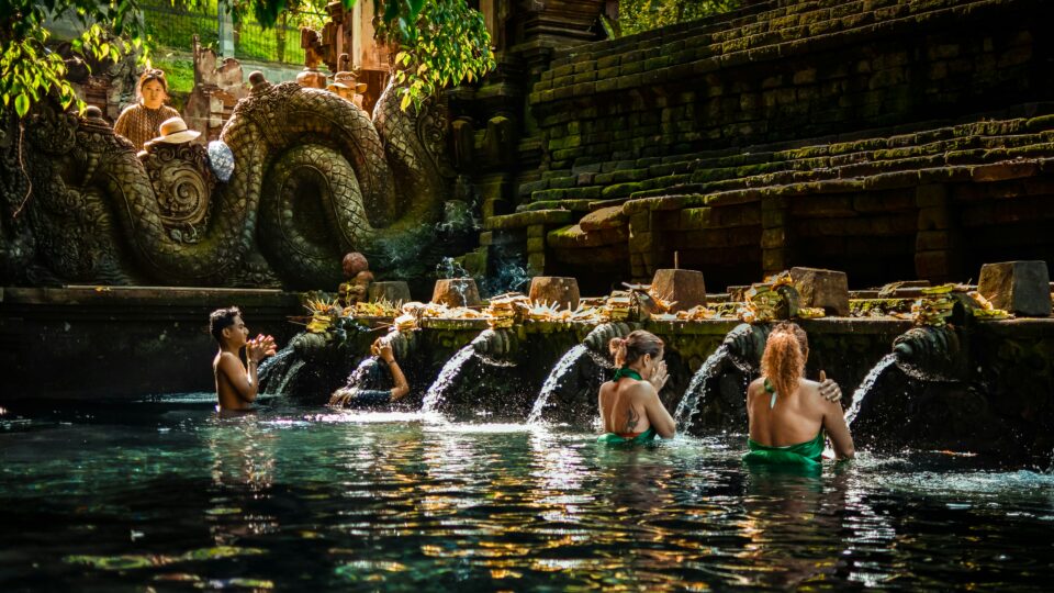 Fidèles en rituel de purification dans les bassins sacrés du temple Tirta Empul à Bali — bali spiritualité