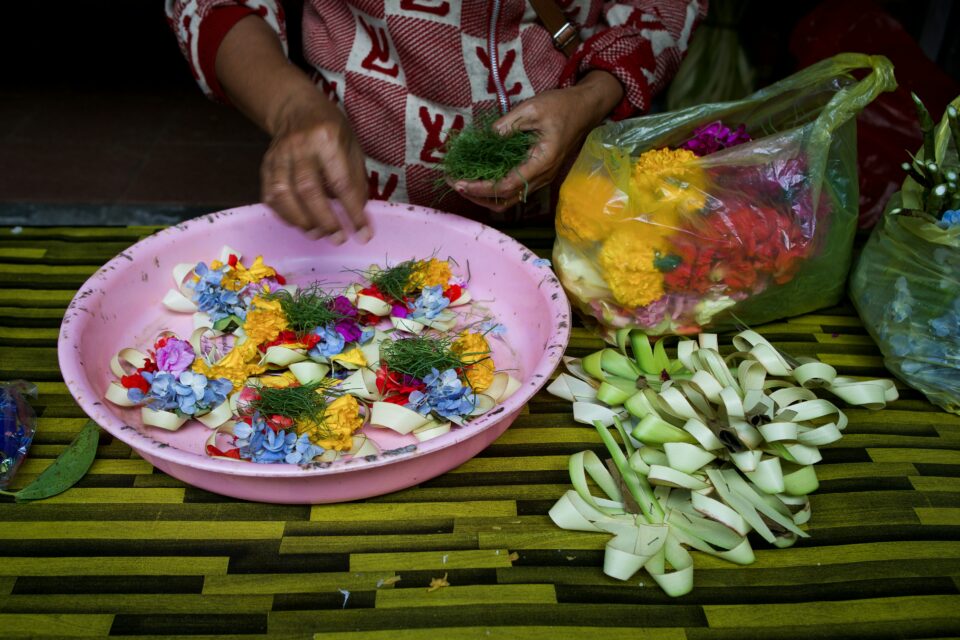 Offrandes traditionnelles canang sari de fleurs et d'encens déposées au sol à Bali — culture balinaise authentique